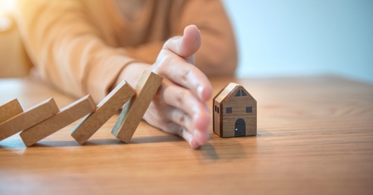 someone stopping domino effect of home figurine